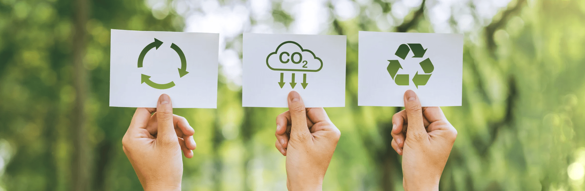 Sustainability is shown with signs held by hands with green background